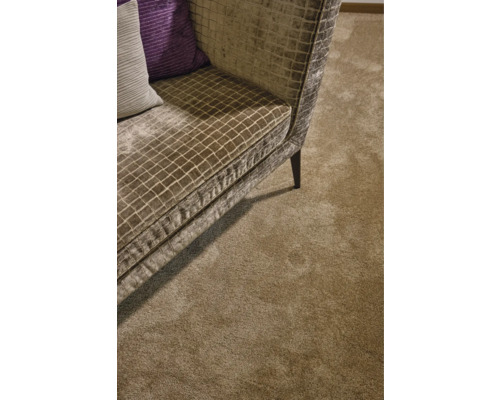 Detailansicht eines Teppichs neben einem Sofa mit kariertem Muster