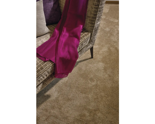 Detailansicht eines Wohnzimmers mit einem Teppich, einem Sessel und dekorativen Kissen.