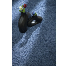 Blauer Teppich mit zwei schwarzen Vasen und Blumen