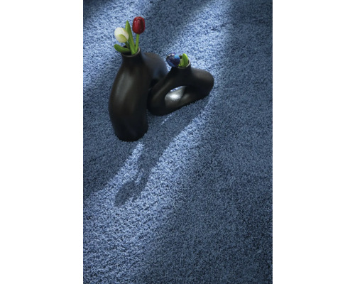 Blauer Teppich mit zwei schwarzen Vasen und Blumen