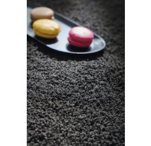 Detailansicht eines schwarzen Teppichs mit Makronen auf einem Serviertablett