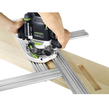 Festool Oberfräse OF 2200 EB wird mit einer Multi-Frässchablone auf einem Holzbrett geführt.