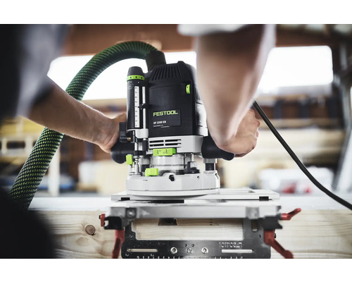 Festool Oberfräse OF 2200 EB bei der Holzbearbeitung in einer Werkstatt mit angeschlossenem Absaugschlauch.