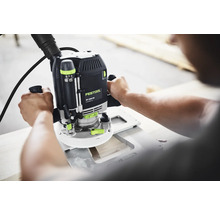 Handgeführte Festool Oberfräse OF 2200 EB mit Festool Logo bei der Holzbearbeitung mit Absaugschlauch.