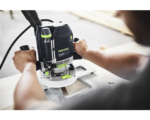 Handgeführte Festool Oberfräse OF 2200 EB mit Festool Logo bei der Holzbearbeitung mit Absaugschlauch.