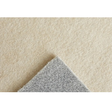 Nahaufnahme eines Nadelfilz-Teppichbodens in Hellbeige mit umgeschlagener grauer Ecke, weiche Oberflächenstruktur.