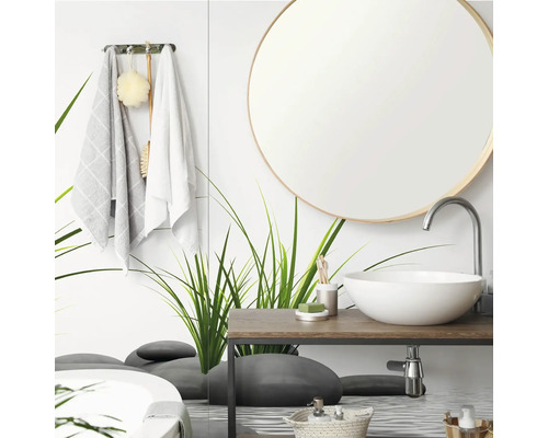 Modernes Badezimmer mit rundem Spiegel, weißem Aufsatzwaschbecken auf einem Holzwaschtisch und einer Glaswand mit Gras- und Steinmotiven.