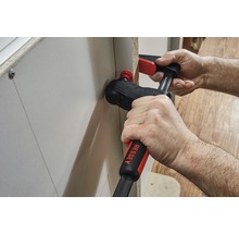 Eine Person verwendet eine Winkelklemme zur Befestigung eines Werkstücks.