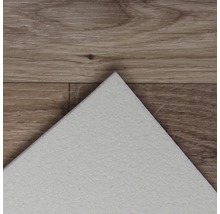 Detailansicht einer weißen Vinylfliese auf einem Holzboden.