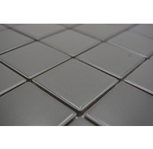 Detailaufnahme von quadratischen, grauen Keramikfliesen.