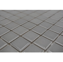 Nahaufnahme von quadratischen, grauen Mosaikfliesen.