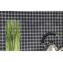 Dekorative grüne Halme und ein Teekessel vor einer Wand mit Mosaikfliesen