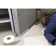 Badezimmerszene mit Abdichtband, Dämmplatten und Handwerker bei der Arbeit