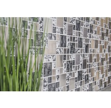 Wand mit quadratischen Mosaikfliesen und Pflanzendekoration