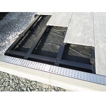 Aufbau einer Terrassenkonstruktion mit Platten, Unterkonstruktion und Entwässerungsrinne.