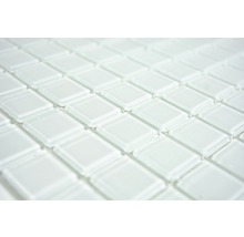 Nahaufnahme von weißen Glasmosaikfliesen, die ein sich wiederholendes Muster bilden.