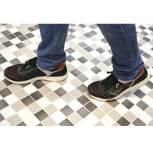 Person mit Schuhen auf Fliesenboden