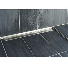 Detailaufnahme eines Duschbereichs mit einer Edelstahl-Duschrinne und dunklen Fliesen