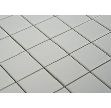 Nahaufnahme von quadratischen Fliesen, die diagonal angeordnet sind und ein wiederholendes Muster bilden.