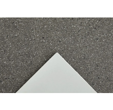 Nahaufnahme einer Arbeitsplatte mit gesprenkelter Oberfläche und einer weißen Platte