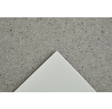 Nahaufnahme einer weißen Fliese auf einer gesprenkelten Oberfläche