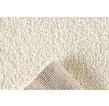 Detailansicht eines beigen Teppichs mit hochflorigem Flor