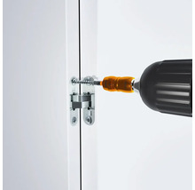 Ein Werkzeug schraubt eine Möbeltürscharnier an einer weißen Tür fest.