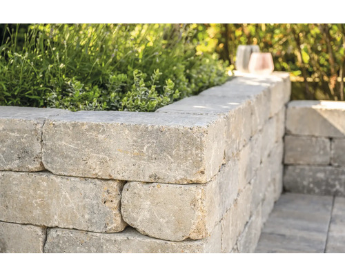 Mauer aus Betonsteinen mit Pflanzen bepflanzt