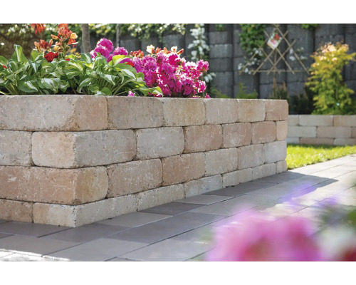 Garten mit einer Mauer aus Steinblöcken und Bepflanzung