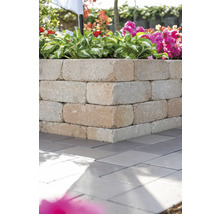 Ecke einer Kräuterspirale aus Betonsteinen im Garten