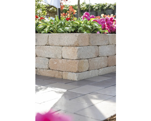 Ecke einer Kräuterspirale aus Betonsteinen im Garten