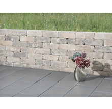 Gartenmauer aus Steinen mit Pflastersteinen und Blumenvase