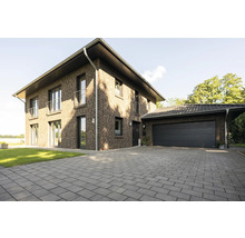 Ein zweistöckiges Backsteinhaus mit Garage und gepflasterter Auffahrt