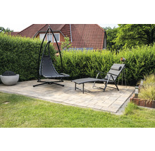 Gartenszene mit Hängekorbsessel, Liegestuhl und Feuerstelle auf einer gepflasterten Terrasse