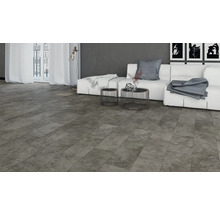 Wohnzimmer mit grauer Steinoptik-Bodenfliese, Couch, Tisch und Fenster für ein helles, modernes Ambiente.