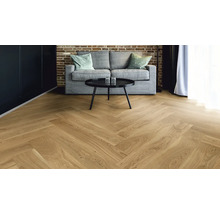 Helle Holzbodenfläche im Fischgrätmuster in einem Wohnzimmer.