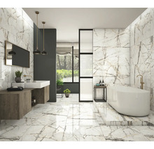 Helles Badezimmer mit Marmorfliesen an Boden und Wänden, Badewanne und Waschtisch