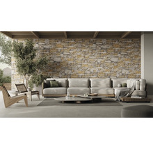 Wohnzimmer mit Ecksofa, Couchtischen und Steinwand