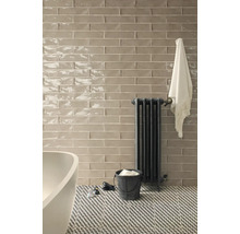 Badezimmer mit Fliesenwand, Heizkörper und gemustertem Boden