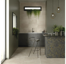 Heller Raum mit Fliesenboden, Küchenzeile, Barhocker und dekorativen Pflanzen.