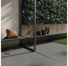 Szene mit grauen Terrassenfliesen, Bank, Kissen und Dekorationselementen