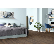 Schlafzimmer mit Bett, Schreibtisch und dunklem Holzboden