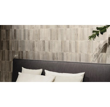 Wandgestaltung mit schmalen, länglichen Fliesen über einem Bett