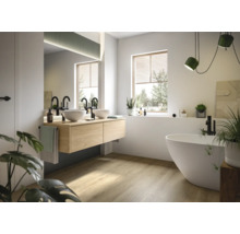 Helles Badezimmer mit Doppelwaschtisch, freistehender Badewanne und Fenster