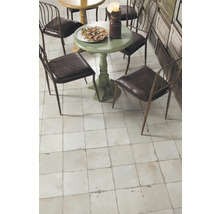 Gedeckter Tisch mit Stühlen auf Fliesenboden