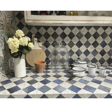 Küchenszene mit Geschirr, Blumen und Schneidebrett auf einer Arbeitsfläche mit Fliesendekor.