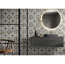 Badezimmer mit Waschbecken, Spiegel und Fliesen mit floralem Muster