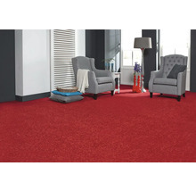 Wohnzimmer mit rotem Teppich, zwei grauen Sesseln und dekorativen Elementen