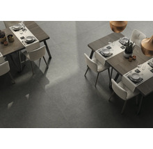 Zwei Esstische mit Stühlen auf grauem Fliesenboden