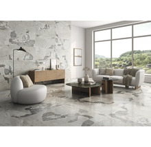 Heller Wohnraum mit Fliesen in Marmoroptik, Sofa und Sessel